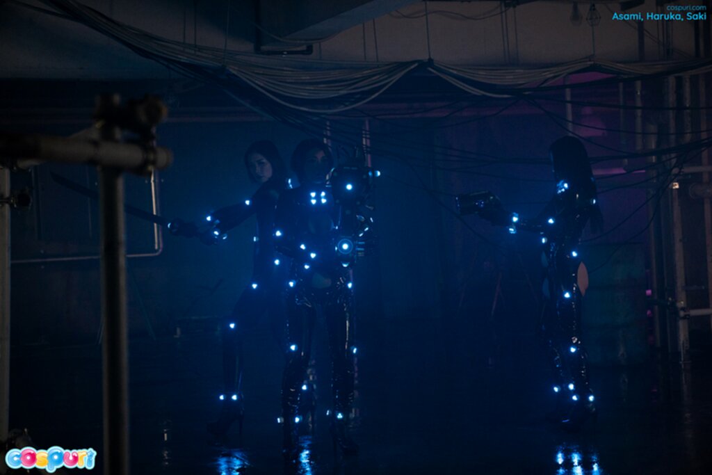 Three women standing in gloom on stage
